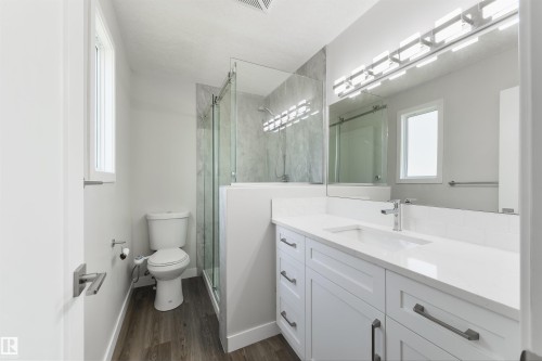 White shaker vanity with a quartz countertop, undermount sink, and chrome faucet - 4614 53 Ave, Calmar, AB - Indoor Photo Showing Bathroom