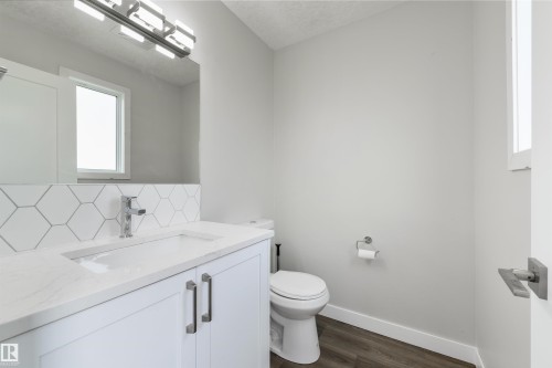 Modern bathroom featuring a white vanity with dual handles, white quartz countertop, and chrome faucet - 4614 53 Ave, Calmar, AB - Indoor Photo Showing Bathroom