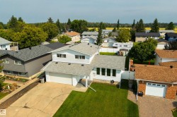 Two-story property with a two-car garage and a manicured front lawn - 