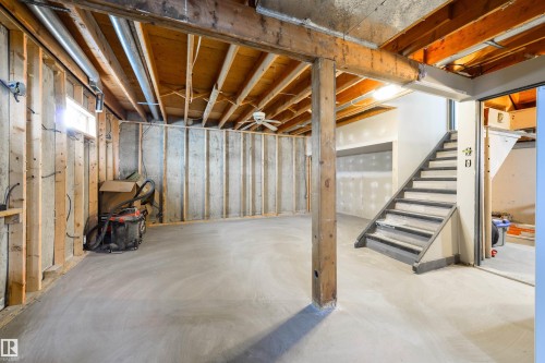 Unfinished basement with exposed wood framing, concrete flooring, and an interior staircase - 4614 53 Ave, Calmar, AB - Indoor Photo Showing Basement