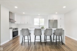 Kitchen featuring white cabinetry, stainless steel appliances, a center island, recessed lighting, and wood-finish flooring - 