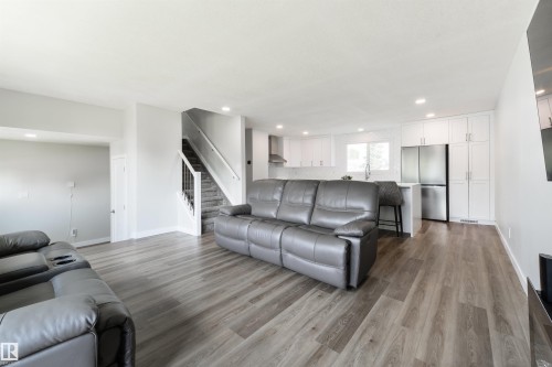 Open-concept living space featuring wood-finish flooring, recessed lighting, and a modern kitchen with white cabinetry - 4614 53 Ave, Calmar, AB - Indoor Photo Showing Living Room
