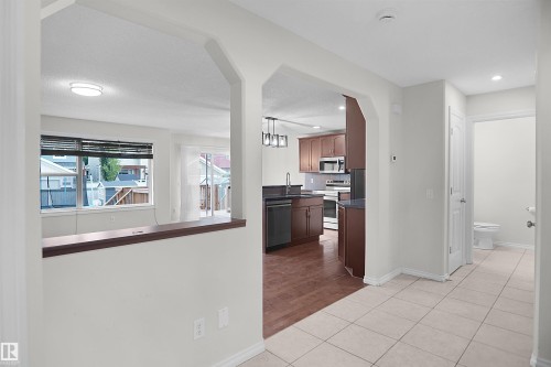 Open floor plan featuring a bright, light-filled living area with recessed ceiling lighting and large windows with wooden sills - 8432 18 Avenue Sw, Edmonton, AB - Indoor Photo Showing Other Room