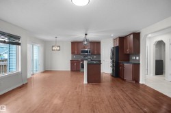 Open-concept living space with wood-finish flooring - 