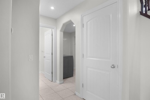 Recessed lighting, tile flooring, arched doorway, paneled interior doors, and a built-in laundry area - 8432 18 Avenue Sw, Edmonton, AB - Indoor Photo Showing Other Room