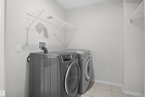Laundry area featuring tiled flooring and white wire shelving - 8432 18 Avenue Sw, Edmonton, AB - Indoor Photo Showing Laundry Room