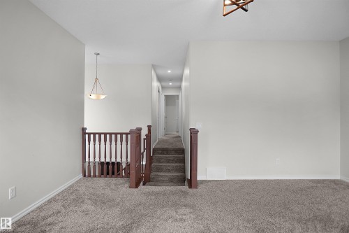Carpeted flooring extending through upper level, recessed lighting, and a chandelier-style fixture - 8432 18 Avenue Sw, Edmonton, AB - Indoor Photo Showing Other Room