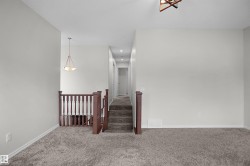 Carpeted flooring extending through upper level, recessed lighting, and a chandelier-style fixture - 