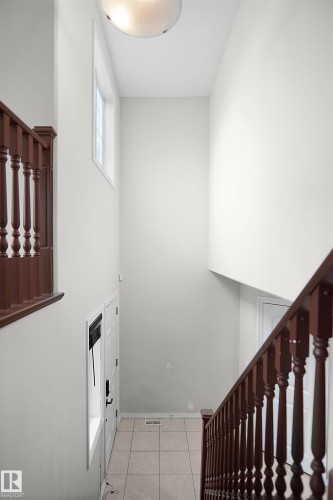 Foyer with tile flooring, wood railings, and a transom window - 8432 18 Avenue Sw, Edmonton, AB - Indoor Photo Showing Other Room