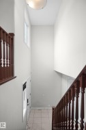 Foyer with tile flooring, wood railings, and a transom window - 