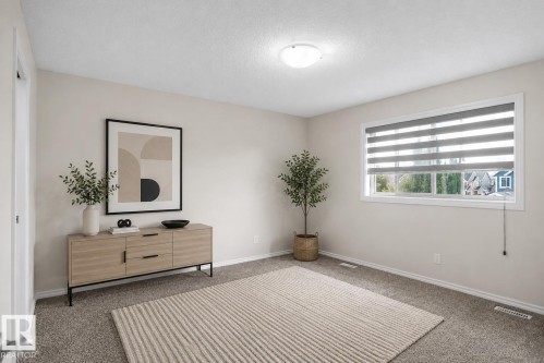Neutral wall color, carpeted flooring, large window with blinds, ceiling-mounted light fixture - 8432 18 Avenue Sw, Edmonton, AB - Indoor Photo Showing Other Room