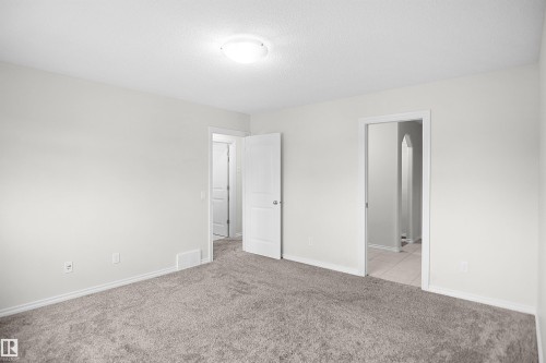 Neutral wall color, carpeted flooring, overhead lighting, white trim, and white interior doors - 8432 18 Avenue Sw, Edmonton, AB - Indoor Photo Showing Other Room