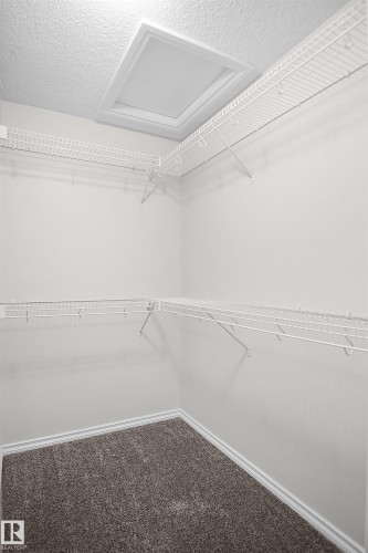 White wire shelving system, recessed ceiling light, wall-to-wall carpeting, and white baseboards - 8432 18 Avenue Sw, Edmonton, AB - Indoor With Storage