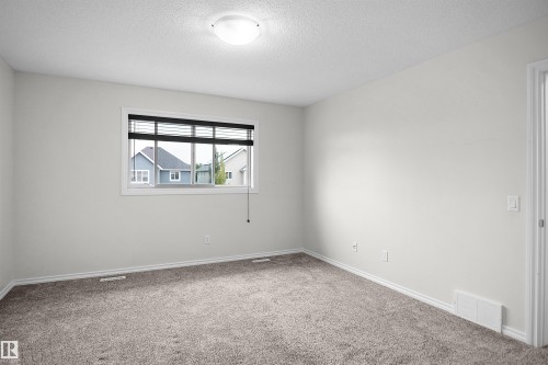 Carpeted flooring, neutral wall tones, single window with blinds, overhead flush mount light fixture - 8432 18 Avenue Sw, Edmonton, AB - Indoor Photo Showing Other Room