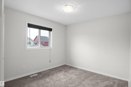Neutral wall finishes, recessed window, dark roller shade, overhead dome light, and gray carpeting - 8432 18 Avenue Sw, Edmonton, AB - Indoor Photo Showing Other Room