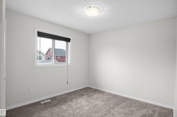 Neutral wall finishes, recessed window, dark roller shade, overhead dome light, and gray carpeting - 