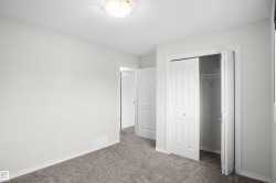 Plush gray carpeting, neutral wall palette, white trim, and bi-fold closet doors with wire shelving - 