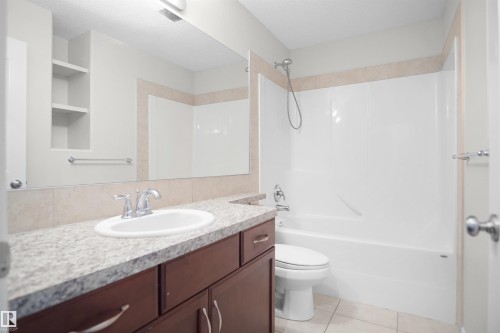 White oval basin with chrome fixtures, set into a speckled countertop - 8432 18 Avenue Sw, Edmonton, AB - Indoor Photo Showing Bathroom