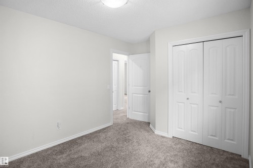 Wall-to-wall carpeting, bi-fold closet doors, and interior paneled doors with chrome hardware - 8432 18 Avenue Sw, Edmonton, AB - Indoor