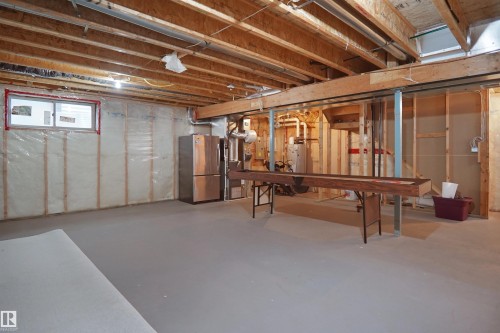 Unfinished basement space with exposed wood joists, insulated walls, and a window - 8432 18 Avenue Sw, Edmonton, AB - Indoor Photo Showing Basement