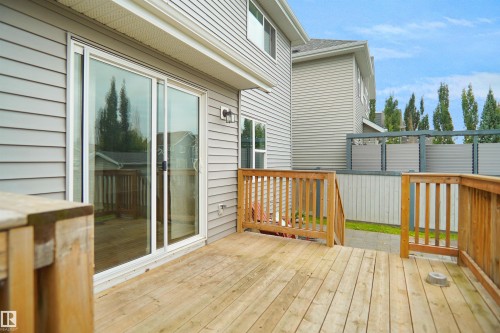 Expansive wood deck with a built-in railing, offering direct access to the interior through sliding glass doors - 8432 18 Avenue Sw, Edmonton, AB - Outdoor With Deck Patio Veranda With Exterior