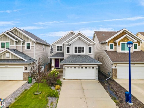 Two-story residence featuring light gray siding, dark gray shingle roof, and a two-car garage - 8432 18 Avenue Sw, Edmonton, AB - Outdoor With Facade