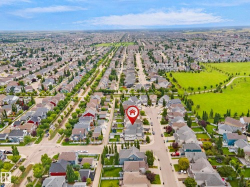 Aerial view of a master-planned community featuring tree-lined streets, consistent architectural styling throughout the neighborhood, manicured green spaces, and organized residential development with ample lot spacing - 8432 18 Avenue Sw, Edmonton, AB - Outdoor With View