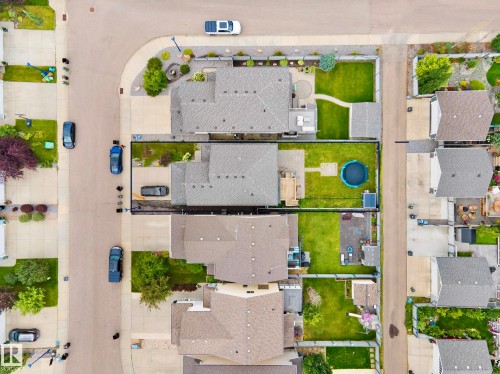 Aerial view showcasing four residential properties with distinct rooflines, manicured lawns, mature landscaping, and private outdoor spaces including a swimming pool - 8432 18 Avenue Sw, Edmonton, AB -  With View