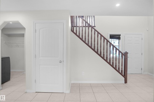 Tile flooring, recessed lighting, white panel doors, wood stair railing - 8432 18 Avenue Sw, Edmonton, AB - Indoor Photo Showing Other Room