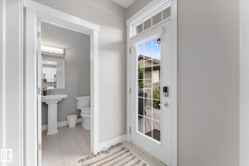 Entry door with transom window, glass panels, and smart lock system - 5616 Juchli Avenue Nw, Edmonton, AB - Indoor Photo Showing Bathroom