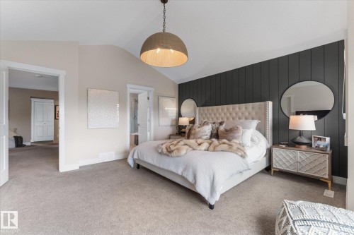 Spacious primary bedroom featuring a tufted upholstered headboard, soft white bedding, and carpeted flooring - 5616 Juchli Avenue Nw, Edmonton, AB - Indoor Photo Showing Bedroom
