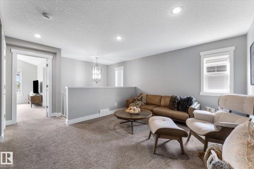 Carpeted landing featuring recessed lighting, a decorative chandelier, and white-trimmed windows - 5616 Juchli Avenue Nw, Edmonton, AB - Indoor Photo Showing Living Room