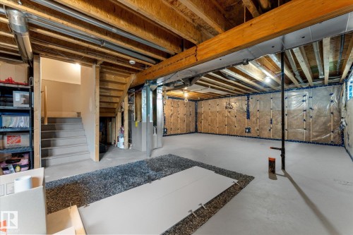 Spacious basement featuring exposed wood beam ceiling, polished concrete flooring with decorative aggregate border, recessed lighting, and built-in cabinetry along the perimeter - 5616 Juchli Avenue Nw, Edmonton, AB - Indoor Photo Showing Basement