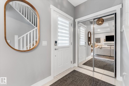 Entryway featuring a white door, mirrored closet doors, and light-toned flooring - 5616 Juchli Avenue Nw, Edmonton, AB - Indoor Photo Showing Other Room