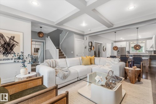 Recessed lighting, coffered ceiling, wood-finish flooring, built-in staircase, and pendant lighting - 5616 Juchli Avenue Nw, Edmonton, AB - Indoor Photo Showing Living Room