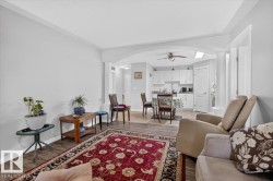 Open-concept living area with wood-finish flooring, recessed lighting, and crown molding - 