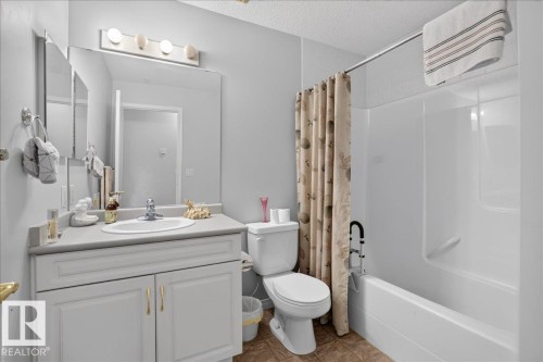 Recessed vanity with integrated sink, chrome faucet, and overhead lighting fixture - #116 237 Youville Dr E Nw, Edmonton, AB - Indoor Photo Showing Bathroom