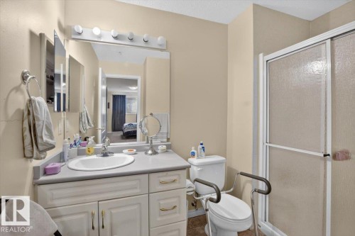 Vanity with integrated sink, chrome faucet, and overhead lighting - #116 237 Youville Dr E Nw, Edmonton, AB - Indoor Photo Showing Bathroom