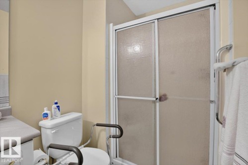 Shower enclosure with frosted glass panels and white framing - #116 237 Youville Dr E Nw, Edmonton, AB - Indoor Photo Showing Bathroom