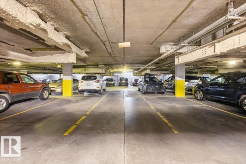 Underground parking garage featuring concrete flooring and structural columns - #116 237 Youville Dr E Nw, Edmonton, AB - Indoor Photo Showing Garage