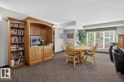 Built-in wooden cabinetry with open shelving and closed storage, patterned carpet flooring, large windows, and recessed ceiling lighting - 