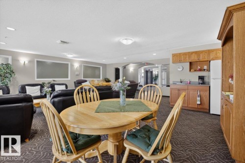 Open-concept living area with patterned carpet flooring - #116 237 Youville Dr E Nw, Edmonton, AB - Indoor Photo Showing Dining Room