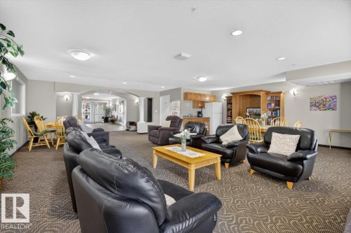 Expansive common area featuring patterned carpeting, recessed lighting, and an arched entry - #116 237 Youville Dr E Nw, Edmonton, AB - Indoor