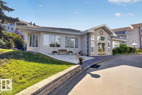 Inviting building entrance with extensive glazing and a gabled roofline - #116 237 Youville Dr E Nw, Edmonton, AB - Outdoor With Facade