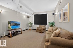 Carpeted room with recessed lighting and a window featuring a roller shade - 