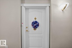 White paneled door with gold-toned hardware and a decorative door knocker - 