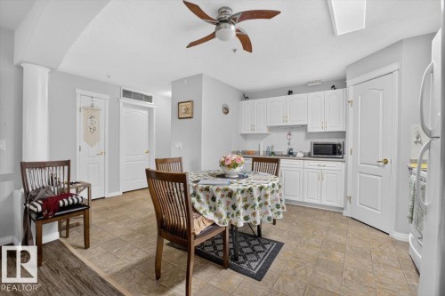 Kitchenette featuring white cabinetry, a built-in microwave, and a ceiling fan - #116 237 Youville Dr E Nw, Edmonton, AB - Indoor Photo Showing Dining Room