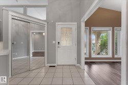 Tiled entryway with a decorative glass front door, mirrored closet doors, and transom windows - 