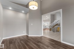 Wood-finish flooring, recessed lighting, drum pendant light, vaulted ceiling, and white trim - 