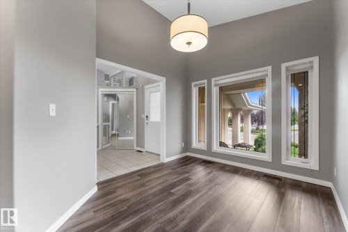 Vaulted ceiling with drum pendant lighting, wood-finish flooring, and multiple windows - 8 Osborne Close, St. Albert, AB - Indoor Photo Showing Other Room